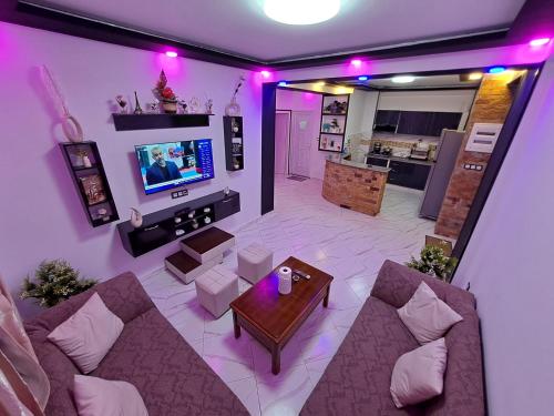 a living room with a couch and a tv and a table at Joli F3 Saket Plage in Bejaïa