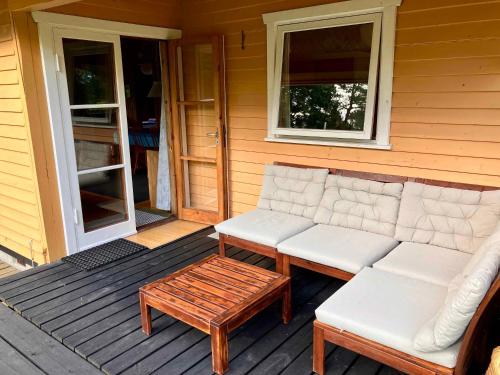 a couch sitting on the porch of a house at Cozy Summer House By Høve Strand in Høve