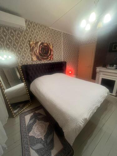 a bedroom with a white bed and a mirror at Chambres royales in Vigneulles-lès-Hattonchâtel