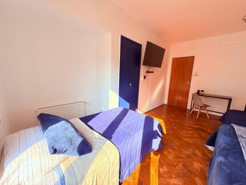a bedroom with two beds and a table in a room at MAKTVB Europa - Hostal Boutique in Santiago