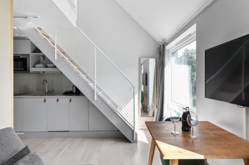 a living room with a staircase and a table with wine glasses at Avanti Apartment Hotel in Stockholm