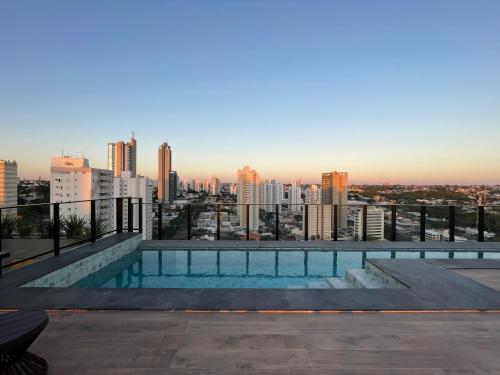 a swimming pool on top of a building with a city skyline at Flat Planejado com Linda Vista e Escritório in Campo Grande