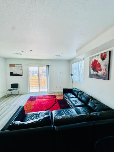 a living room with a black couch and a red rug at The Ostel in Los Angeles