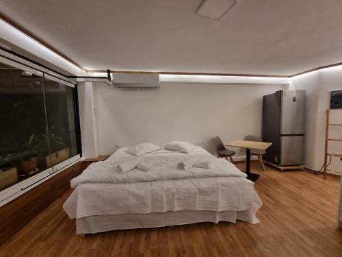 a bedroom with a bed and a large window at Loft apartment by the sea in Athens