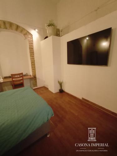 a bedroom with a bed and a tv on the wall at Casona Imperial in Tepic