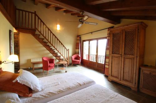 a bedroom with a large bed and a staircase at Mas D'en Roqueta in Aravell