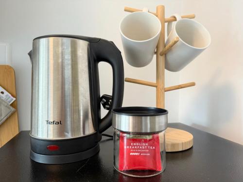 a tea kettle on a counter next to some cups at Spacious 1 Bedroom, with sofa bed and Balcony in Kathu