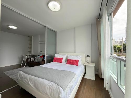 a bedroom with a large bed with red pillows at Spacious 1 Bedroom, with sofa bed and Balcony in Kathu