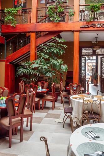 a restaurant with tables and chairs and plants at Hotel Campanario in Cuenca