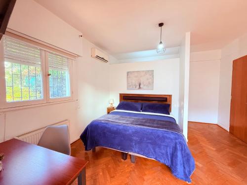 a bedroom with a bed with a blue bedspread at MAKTVB Europa - Hostal Boutique in Santiago