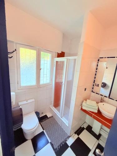 a bathroom with a toilet and a sink and a shower at MAKTVB Europa - Hostal Boutique in Santiago