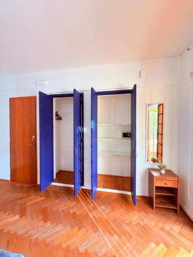 a room with blue doors and a wooden floor at MAKTVB Europa - Hostal Boutique in Santiago
