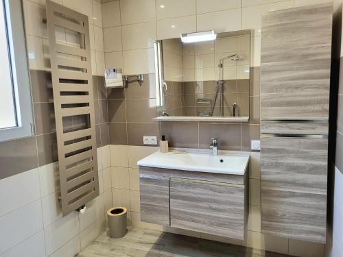 a bathroom with a sink and a mirror at Les Antilles, maison de bord de mer in Pirou