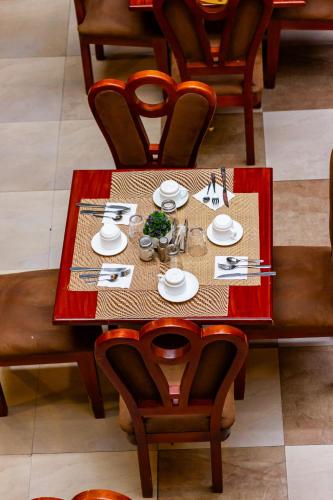 a dining room table with plates and utensils on it at Hotel Campanario in Cuenca