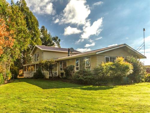 a house with a green lawn in front of it at Raetihi Garden Spa Villa in Raetihi