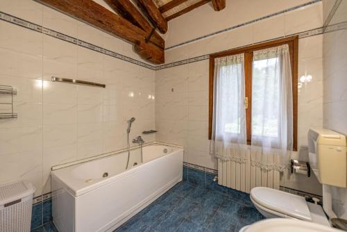 a bathroom with a tub and a toilet and a sink at Villa Navagero - Ca' Degli Stefani A in Rovarè