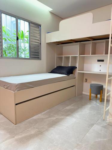 a bedroom with a large bed and a window at Casa com Piscina, área Gourmet e Ar Condicionado in Sumaré