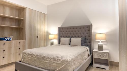 a bedroom with a large bed and two lamps at Stunning 2BR Condo - 5 Min to Beach in Cabo San Lucas