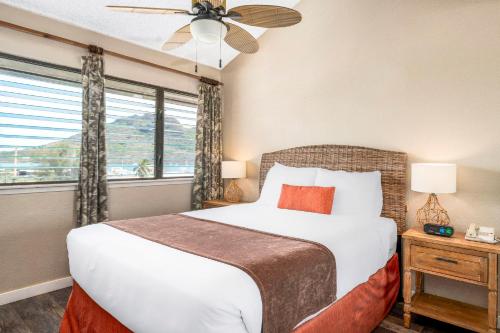 a bedroom with a bed and a window at Banyan Harbor Resort in Lihue