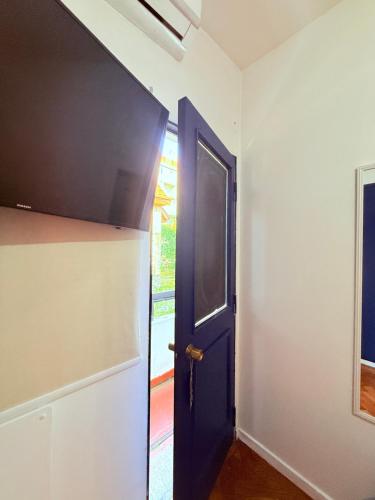 an empty room with a blue door and a window at MAKTVB Europa - Hostal Boutique in Santiago