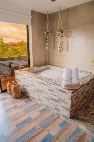 a jacuzzi tub with two chairs in a bathroom at Cabañas con jacuzzi y chimenea - Casa Floral, Marinilla in Marinilla