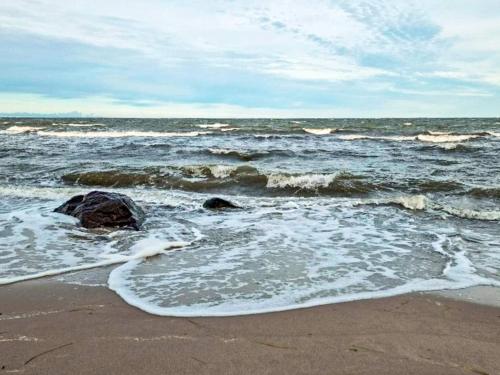 a beach with waves and rocks in the ocean at Tranquil Beach Retreat - By Traum in Idestrup