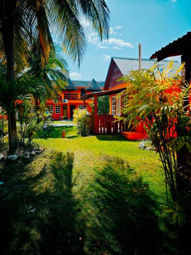 a house with a palm tree in front of a yard at Hotel Mirador Maya Calakmul in Xpujil