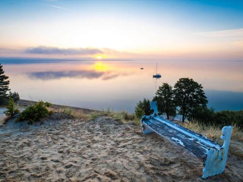 a bench sitting on the beach near the water at 6 person holiday home in Børkop-By Traum in Børkop