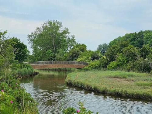 a bridge over a river with a riverurrencyternessternessternessstrationstrationstrationstration at 6 person holiday home in Bjert-By Traum in Binderup Strand