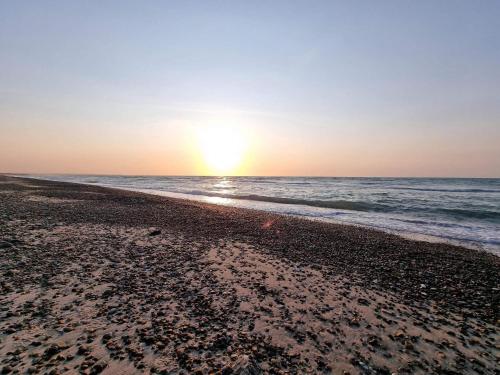 a beach with the sun rising over the ocean at 10 person holiday home in Fjerritslev-By Traum in Fjerritslev