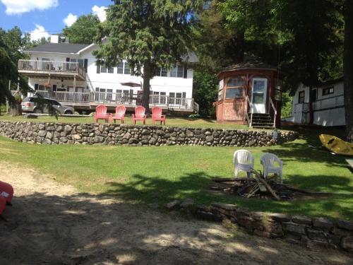 a group of chairs in a yard with a house at Little Hawk Resort & Marina in Algonquin Highlands