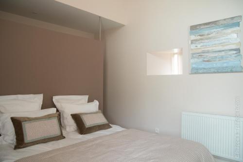 a bedroom with a bed with white sheets and pillows at Les Hauts De Chalonne in Le Gond-Pontouvre