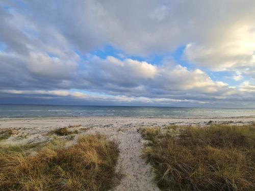a sandy beach with the ocean on a cloudy day at Luxury Retreat by Beach - By Traum Ferienwohnungen in Marielyst
