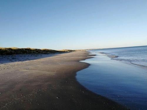 an empty beach with the ocean in the background at 6 person holiday home in Ålbæk-By Traum in Ålbæk