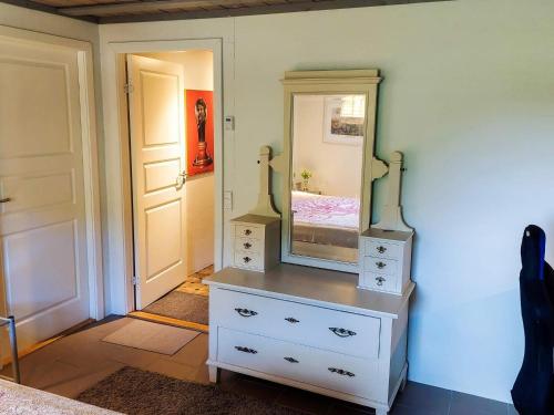 a bedroom with a dresser with a mirror on it at 6 person holiday home in Thisted in Thisted
