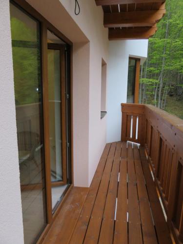 a balcony of a house with wooden floors and windows at Apartmán Chopok Juh Romantika 14 in Tale