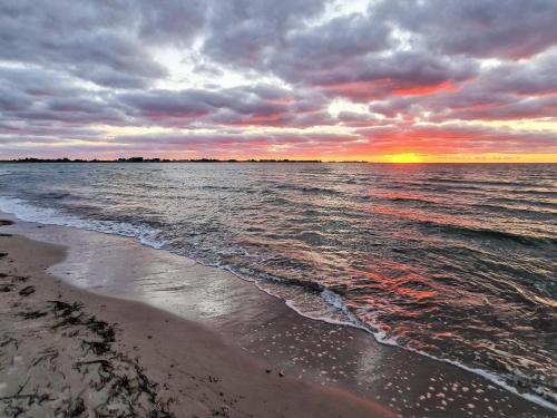 a sunset over the ocean on a beach at Seaside Retreat in Havnso-By Traum in Føllenslev