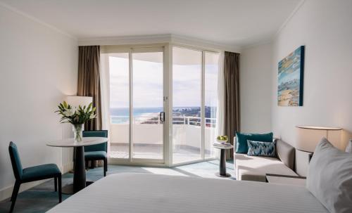 a hotel room with a bed and a view of the ocean at Rendezvous Hotel Perth Scarborough in Perth