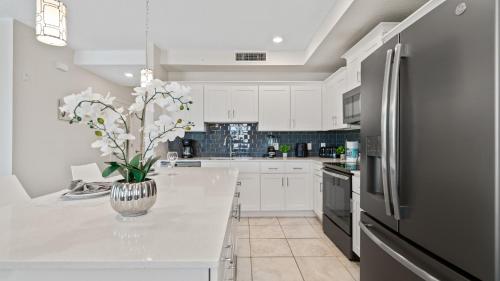 a kitchen with white cabinets and a black refrigerator at Beautiful Apartments 5 Minutes away from Disney! in Kissimmee