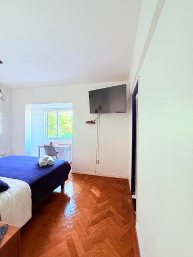 a bedroom with a bed and a desk and a tv at MAKTVB Europa - Hostal Boutique in Santiago