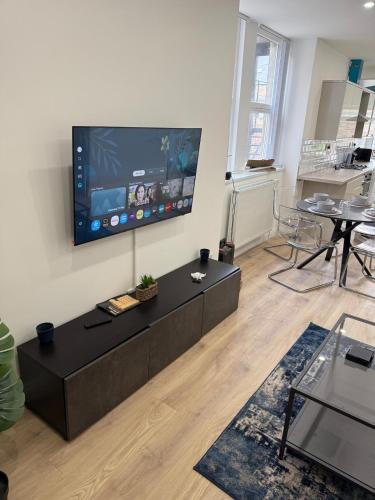 a living room with a large flat screen tv on the wall at Modern 2 Bedroom Flat - Central & Stylish in Newcastle upon Tyne