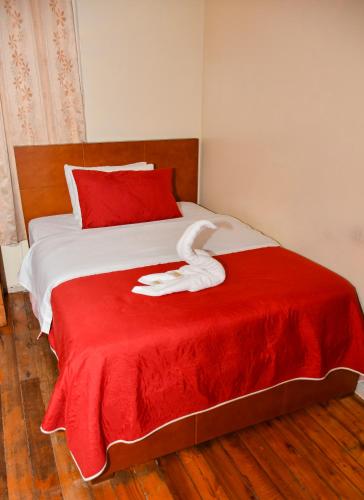 a red and white bed with a white towel on it at Hostal Bolívar Inn in Quito