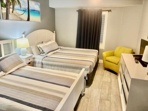 Un dormitorio con dos camas y una silla. en Ocean Walk Resort - Spectacular Ocean Front View, en Daytona Beach