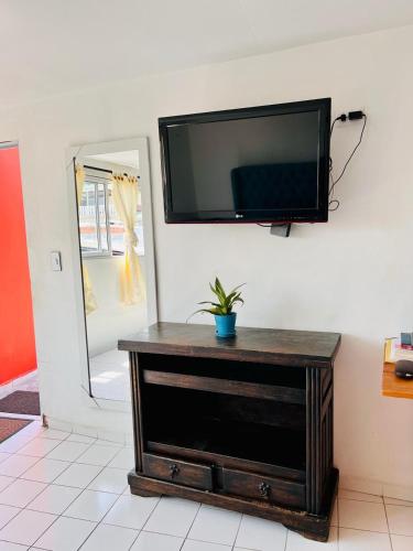 a flat screen tv hanging on a wall at ApartaEstudios San Cayetano Cali in Cali