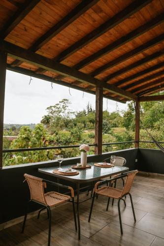 a table and chairs on a porch with a view at Cabañas con jacuzzi y chimenea - Casa Floral, Marinilla in Marinilla