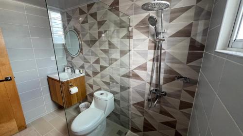 a bathroom with a shower with a toilet and a sink at Santiago Serenity in Santiago de los Caballeros