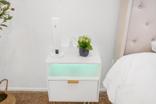 a nightstand with a plant on it next to a bed at Westlake Village Escape 2 Bedroom 2 Bath with Pool & Jacuzzi View! Welcome Champagne in Westlake Village