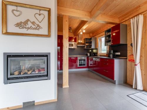 a kitchen with red cabinets and a fireplace at Die Bergliebe in Hohentauern