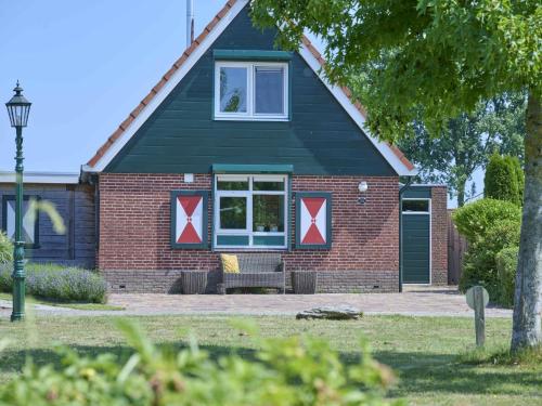 a red brick house with a black roof at Poldergeluk in Ooltgensplaat