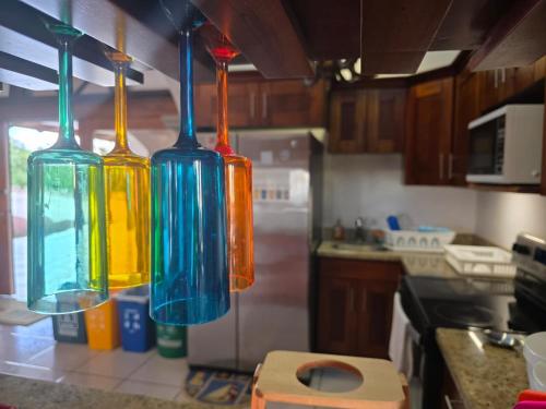 three colorful glass vases hanging in a kitchen at Casona Cocobolo el mejor lugar de Costa Rica in Guanacaste